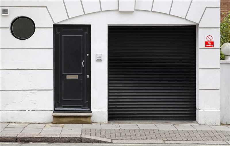 Black garage and entrance door at white house